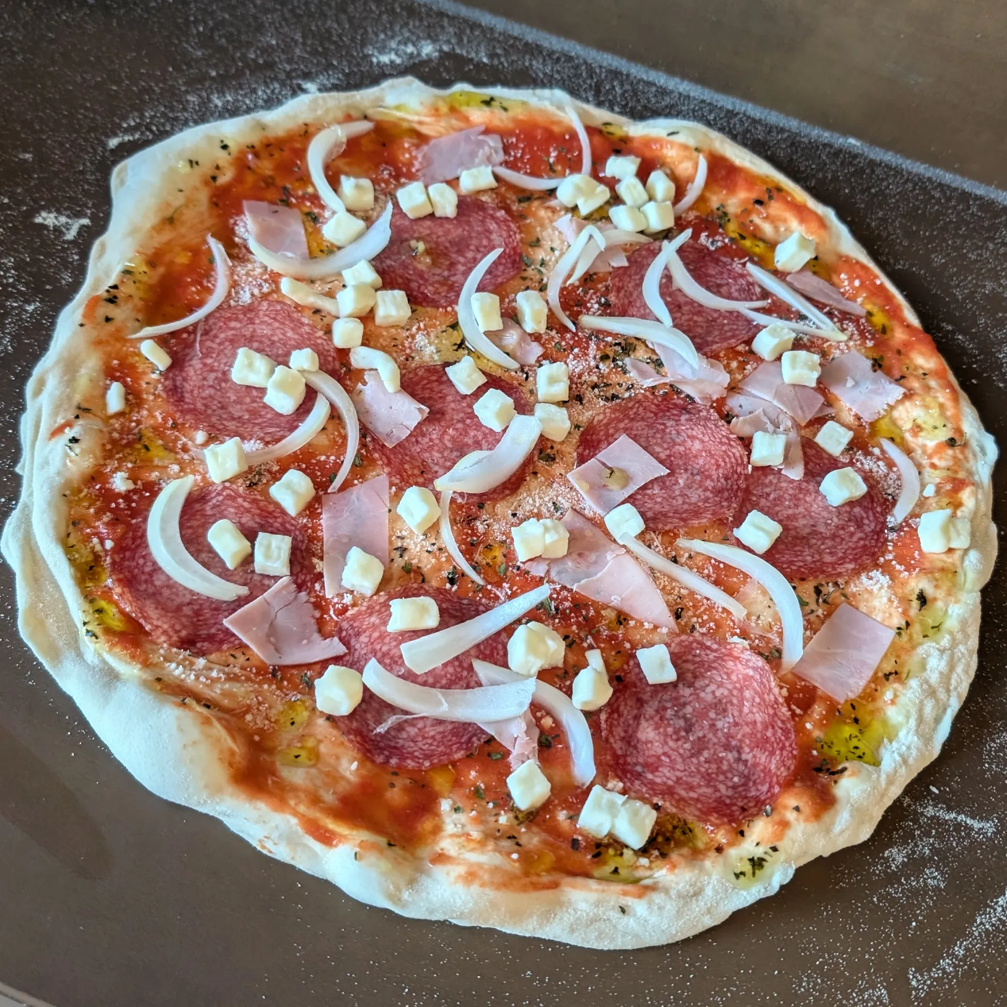 Roh belegte Pizza mit Tomatensauce und Käse vor dem Backen.