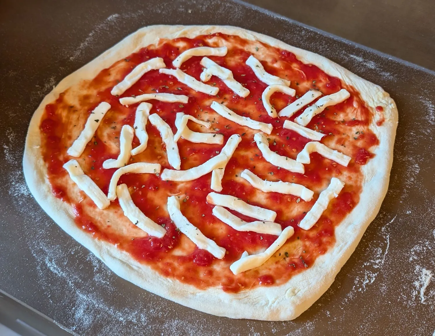 Roh belegte Pizza mit Tomatensauce und Käse vor dem Backen.