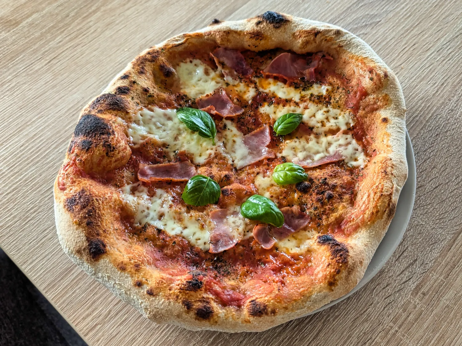 Frisch gebackene Pizzen mit aufgegangenem Rand auf einem Teller.